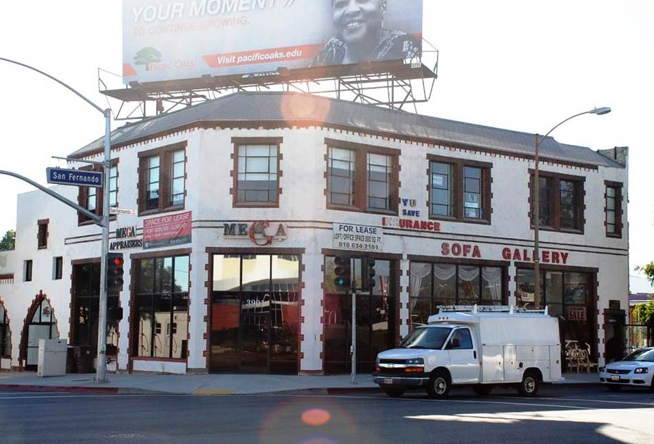 Two story white mixed-use building on a corner lot.