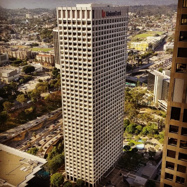 Aerial image of white skyscraper surrounded by green landscaping