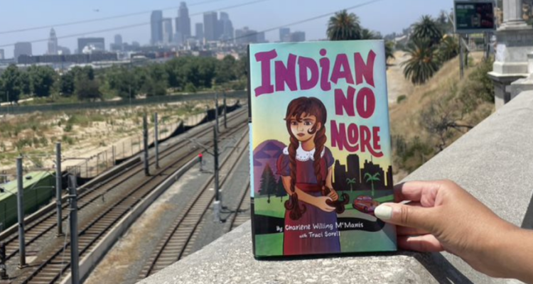 Indian No More book with a view of train tracks and downtown skyline