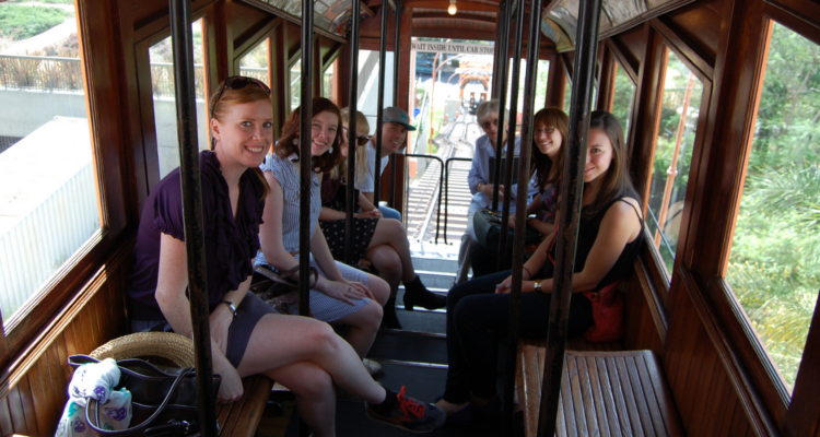 Group of smiling people riding Angels Flight in downtown Los Angeles.