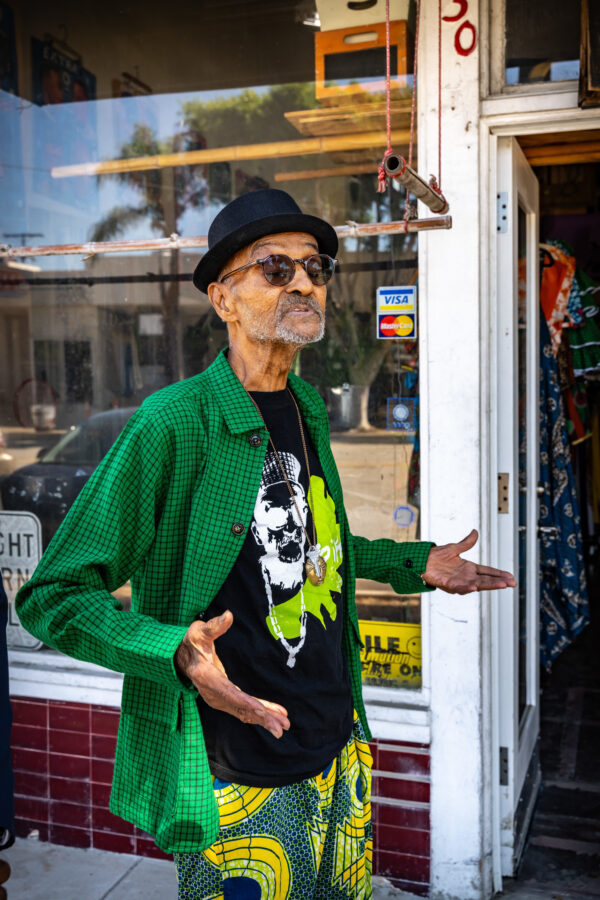 Elderly black man posing with arms out.