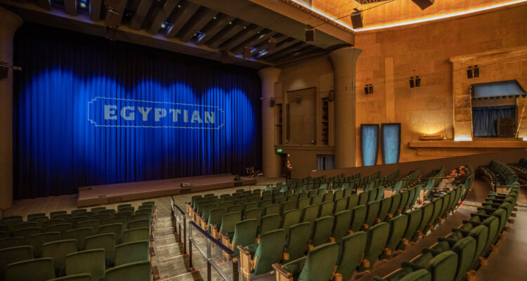 Green theatre seats with text of Egyptian on blue curtain backdropoff