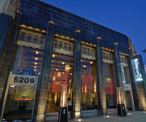 The Deco building at night with lights on