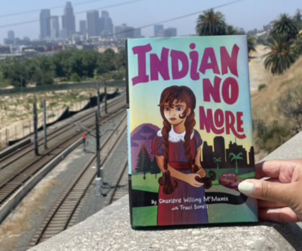 Indian No More book with a view of train tracks and downtown skyline