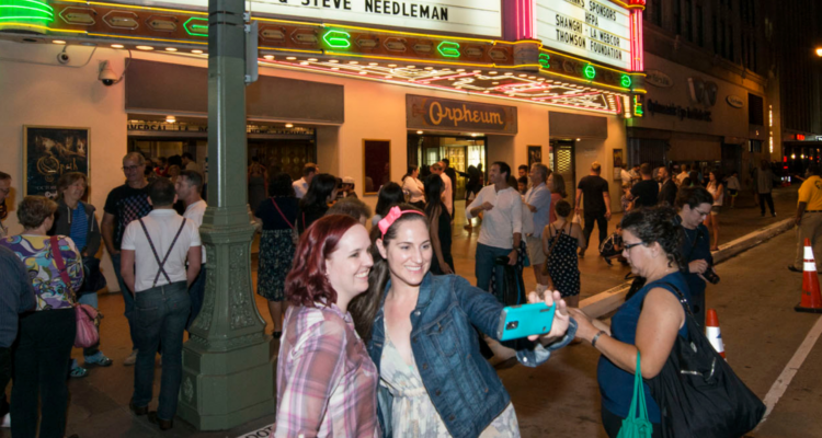 Two people take a selfie in front of the Orpheum Theatre.