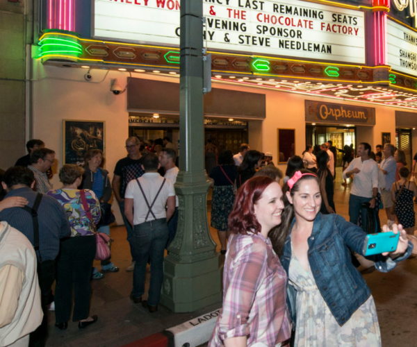 Two people take a selfie in front of the Orpheum Theatre.