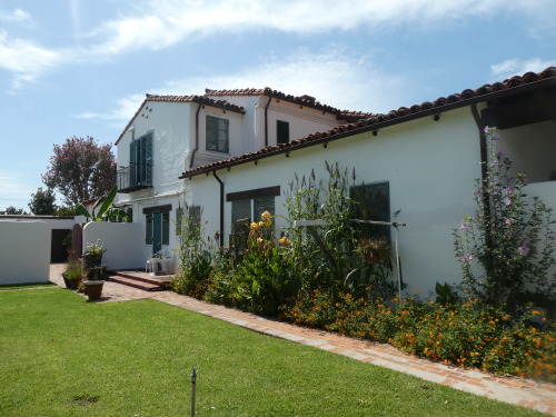 A side view of a white house with green grass.