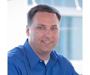 headshot of man in blue shirt