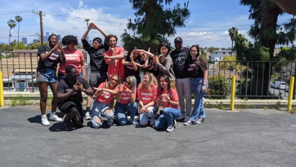 A group of students in black and salmon colored shirts posing for a picture