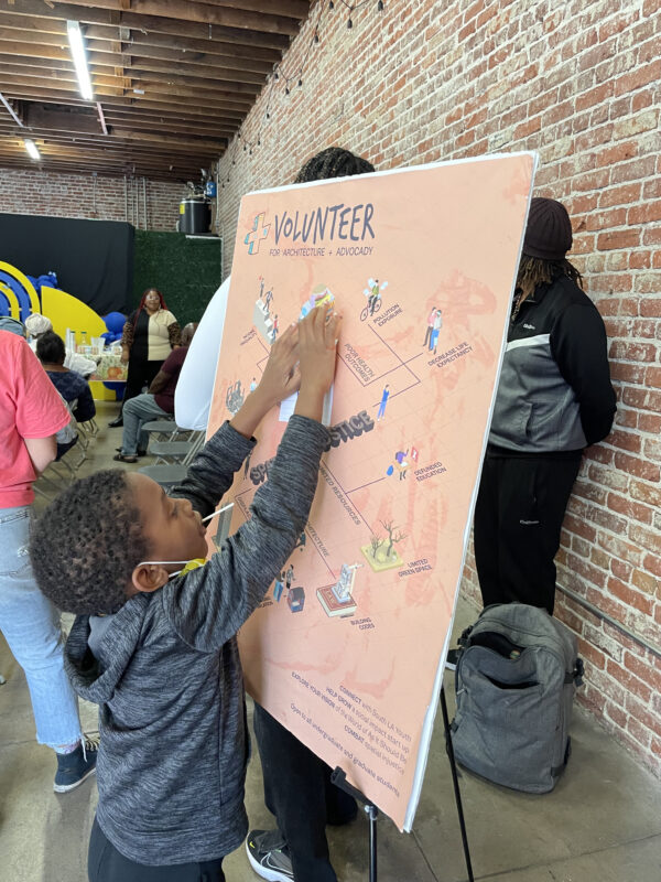 African American child placing a paper on a salmon color board.