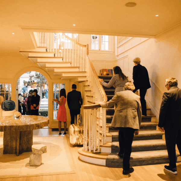 Several individuals walking up a staircase, showcasing a mix of ages and engaged in conversation and enjoying their surroundings.