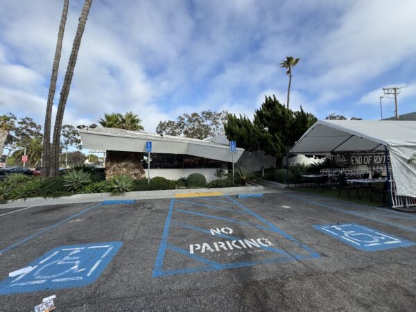 A side view of Mel's from the parking lot, with some outdoor dining visible