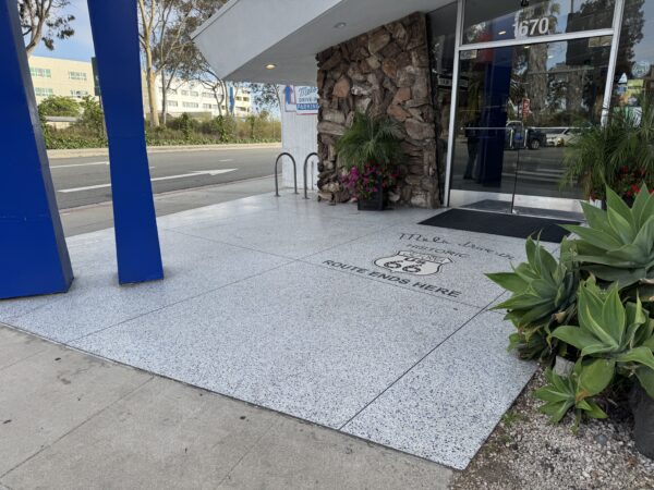 Restored terrazzo in front of Mel's with a commemorative Route 66 route marker